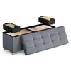 A storage ottoman with its lid open, showing internal compartments and organizers filled with folded items. Produktbild-Vorschau