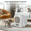 A kitten is walking towards a large, white, enclosed litter box in a modern living room setting. Podgląd zdjęcia produktu