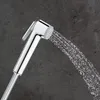 A close-up shot of a chrome bidet spray head with water spraying from it, set against a dark gray textured background. Náhľad obrázku produktu
