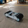 A transport roller with multiple wheels on a concrete floor in what appears to be a warehouse or workshop. Podgląd zdjęcia produktu