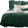 A close-up view of a bed with green bedding and decorative pillows. Podgląd zdjęcia produktu