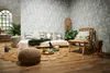 A cozy living room scene with a sofa, chair, and decorative items, featuring a tropical-themed wallpaper. Produktbild-Vorschau