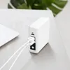 A white power bank with two USB cables plugged into it, sitting on a light-colored surface next to a white laptop. Podgląd zdjęcia produktu