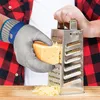 A person wearing a protective glove is grating cheese with a grater. Produktbild-Vorschau