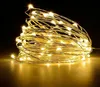 A coiled string of warm white LED lights with a copper wire, set against a dark background. Produktbild-Vorschau