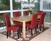 A dining room with a wooden table and six red chairs, set in a sunroom with large windows. Produktbild-Vorschau