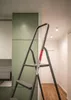 A stepladder is positioned in a hallway next to a green cabinet. Anteprima dell’immagine prodotto