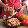 A person is grating cheese over a plate of pasta. A loaf of bread and a tomato are also visible. Anteprima dell’immagine prodotto