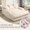 A beige corduroy sofa with pillows in a living room setting. Náhled obrázku produktu