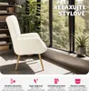 A fluffy cream armchair with gold legs is placed in a bright room with large windows overlooking greenery. The image is overlaid with text and icons highlighting product features. Náhled obrázku produktu