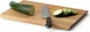 A cutting board with a zucchini and a knife. Voir les images du produit