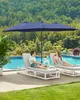 A couple relaxing on lounge chairs by a pool under a large umbrella. Produktbild-Vorschau