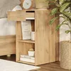 A wooden nightstand next to a bed, with a plant in a basket nearby. Náhled obrázku produktu