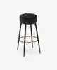 A black bar stool with a round velvet seat and gold footrest, isolated on a white background. Podgląd zdjęcia produktu
