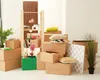 Cardboard boxes and moving supplies are arranged in a room, suggesting a move or storage. Anteprima dell’immagine prodotto