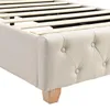 A close-up view of the corner of a bed frame, showing the upholstered side and a wooden leg. Náhled obrázku produktu
