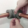 Hands are shown installing pipe insulation on copper pipes. Produktbild-Vorschau