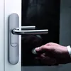 A person is using a key fob to unlock a door with a modern handle. Produktbild-Vorschau