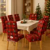 A dining room set up for Christmas, with chairs covered in festive red and black plaid slipcovers featuring Christmas motifs. Náhled obrázku produktu