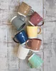 A collection of ceramic mugs arranged on a distressed wooden surface. Produktbild-Vorschau