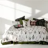 A bed with a winter-themed duvet cover and several decorative pillows. Produktbild-Vorschau