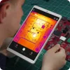 A person is using a tablet to view a thermal image of a circuit board. Voir les images du produit