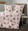 A bed with a duvet cover and pillow set featuring a deer pattern, placed in a bedroom setting. Produktbild-Vorschau