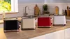 Four Bosch toasters in different colors are displayed on a kitchen counter. Voir les images du produit