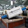 A Calconditioner CC2500 electronic descaler is shown attached to pipes in what appears to be a commercial or public space with counters and seating. Voir les images du produit