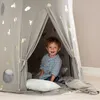 A young child is sitting inside a tent decorated with space-themed patterns. Podgląd zdjęcia produktu