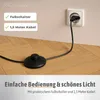 A black foot switch and power cord for a lamp are shown on a wooden floor, plugged into a wall socket. Text overlays highlight features. Produktbild-Vorschau