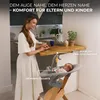 A woman is preparing food in a kitchen while a baby is in a high chair next to her. Voir les images du produit