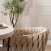 A close-up of a beige woven chair next to a round table. Produktbild-Vorschau