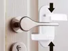 A white door handle lock is being demonstrated on a white door. Náhled obrázku produktu
