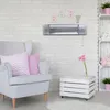 A baby's room with a heater mounted on the wall, a chair, and decorative items. Anteprima dell’immagine prodotto