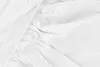 A close-up view of a white fitted sheet with elasticized edges. Produktbild-Vorschau