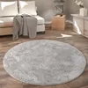 A round, shaggy rug in a living room setting with a sofa and side table. Voir les images du produit