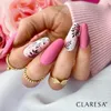 A hand with pink matte nails decorated with black leaf designs, wearing gold rings, against a backdrop of pink fabric and a pink rose. Náhled obrázku produktu