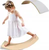 A young girl is balancing on a wooden board. Produktbild-Vorschau
