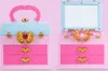 A split image showing a pink and light blue toy makeup case with gold accents. The left side shows the case closed with a handle, and the right side shows it open with a mirror and compartments. Produktbild-Vorschau