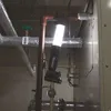 A work light illuminates pipes and equipment in what appears to be a utility or industrial setting. Produktbild-Vorschau