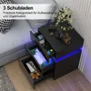 A black nightstand with three open drawers, displaying various items, next to a sofa and a wall with striped wallpaper. Blue LED lights are visible on the nightstand. Produktbild-Vorschau