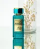 A bottle of perfume is displayed on a reflective surface with a blurred background of dried flowers in a glass vase. Produktbild-Vorschau