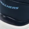 A close-up view of a navy blue SKECHERS sneaker, showing the textured material and the brand name. Voir les images du produit