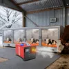Calves in heated enclosures in a barn during winter, with a heater in the foreground. Voir les images du produit