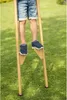 A child is standing on stilts in a grassy area. Anteprima dell’immagine prodotto