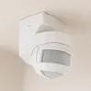 A white motion sensor is mounted on a textured white ceiling and wall. Produktbild-Vorschau