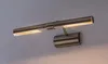 A close-up shot of a picture light mounted on a wall. Podgląd zdjęcia produktu