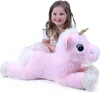 A young girl sits behind a large, plush pink unicorn. Produktbild-Vorschau