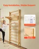 A woman is performing a yoga pose next to a wooden wall-mounted ladder in a room. Produktbild-Vorschau